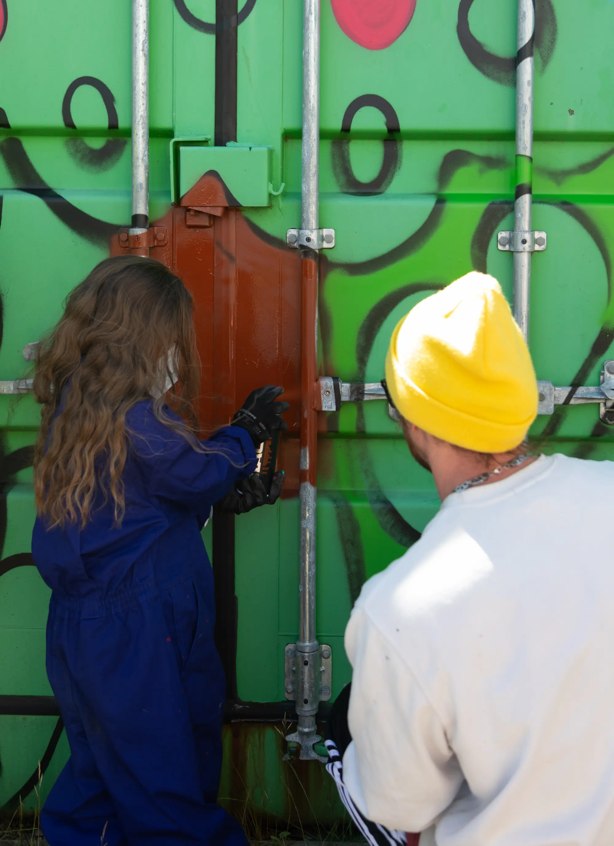 Community members and Tragic O'Hara painting a mural together