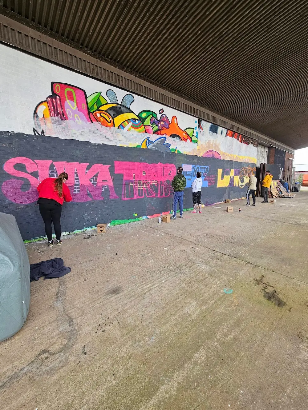 A student learning spray painting technique at Shred Skatepark